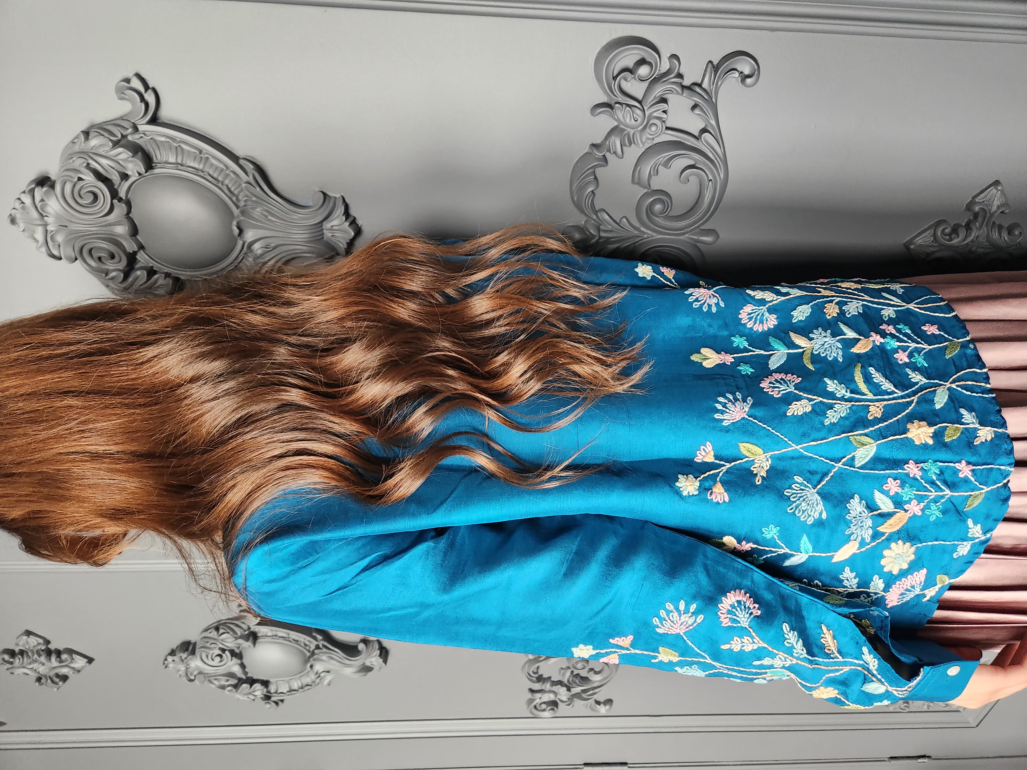 Model showing teal blue embroidered jacket back detail
